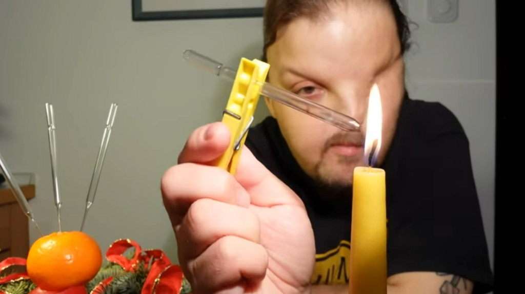 Videovorschau: Lars Fischer hält ein Glasröhrchen an einer Wäscheklammer in die Flamme einer Kerze.